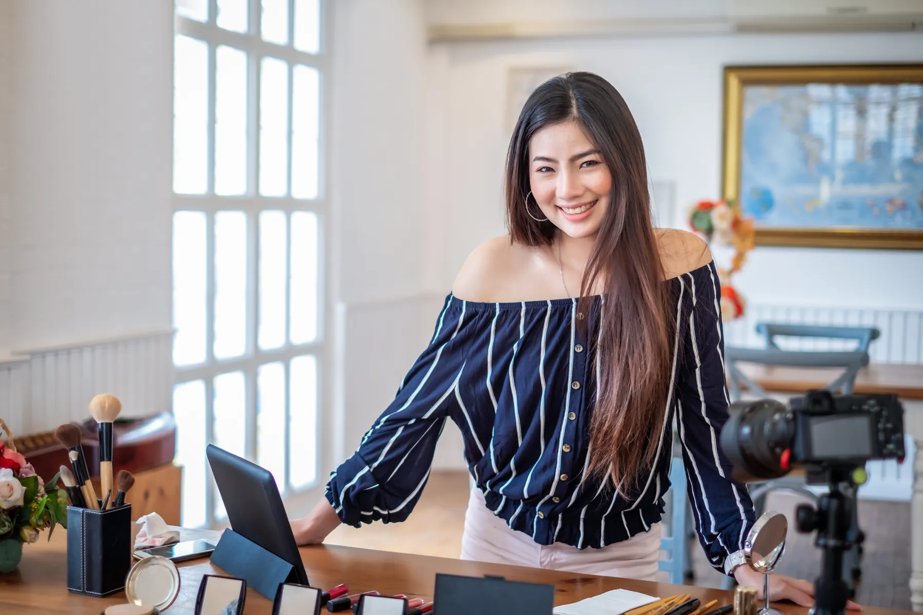Small business owner filming content at her desk with a camera